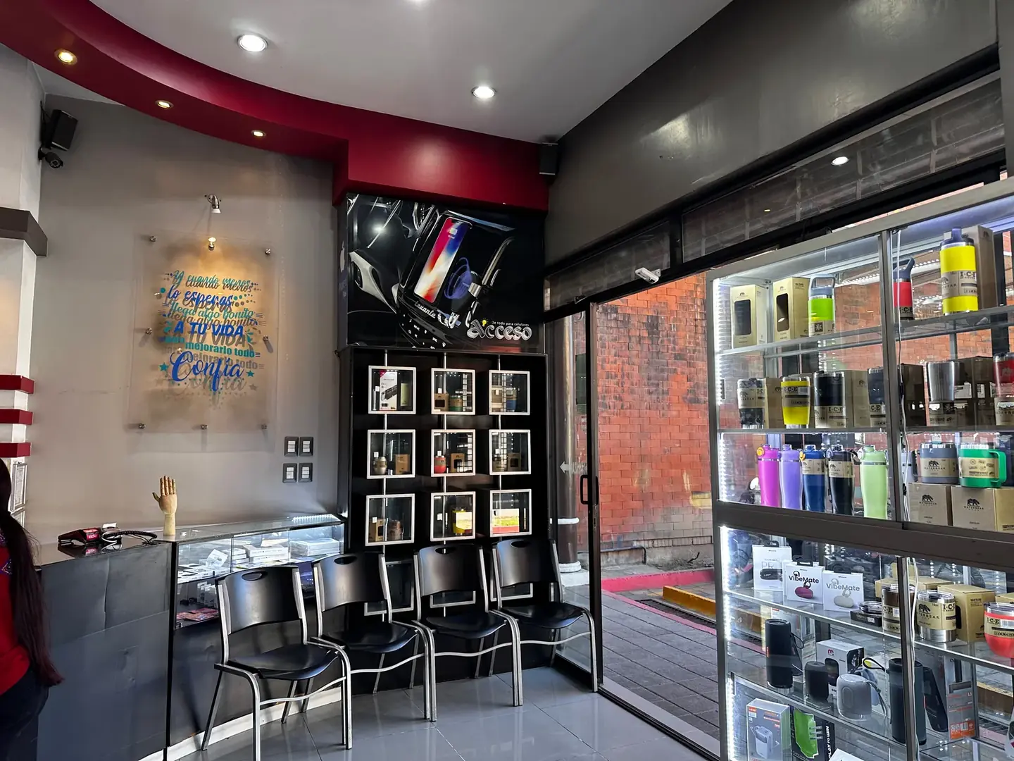 Interior de la tienda con vitrina de vasos térmicos y parlantes